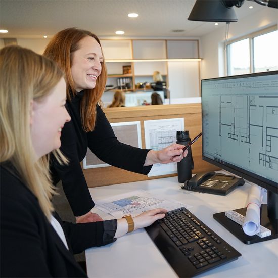 Architekten besprechen Grundriss am PC