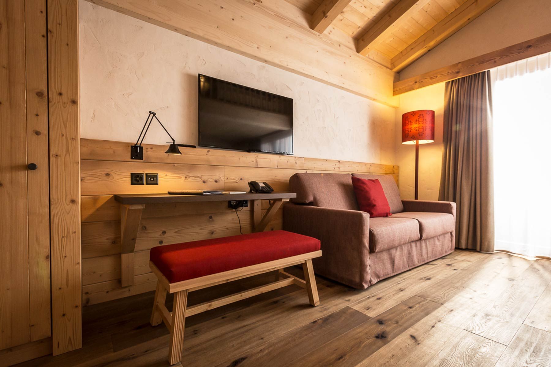 Einrichtung die zum Hotelcharakter passt mit Couch, Holzhocker und Lampen