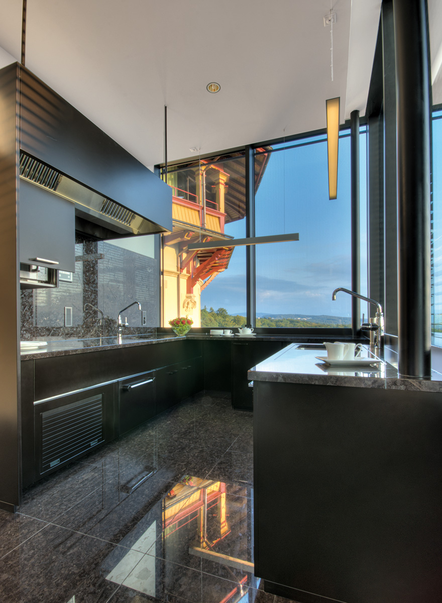 Moderne Küche in dunklen Farben mit Blick auf Zürich